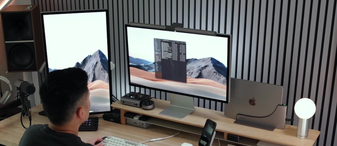A desk with two monitors and a MacBook standing closed in the Ascrono dock